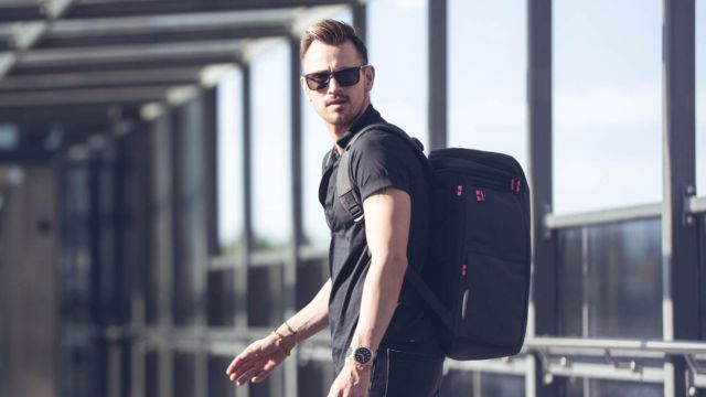 Man med ryggsäck som går ombord på ett flygplan och ska använda ryggsäcken som handbagage